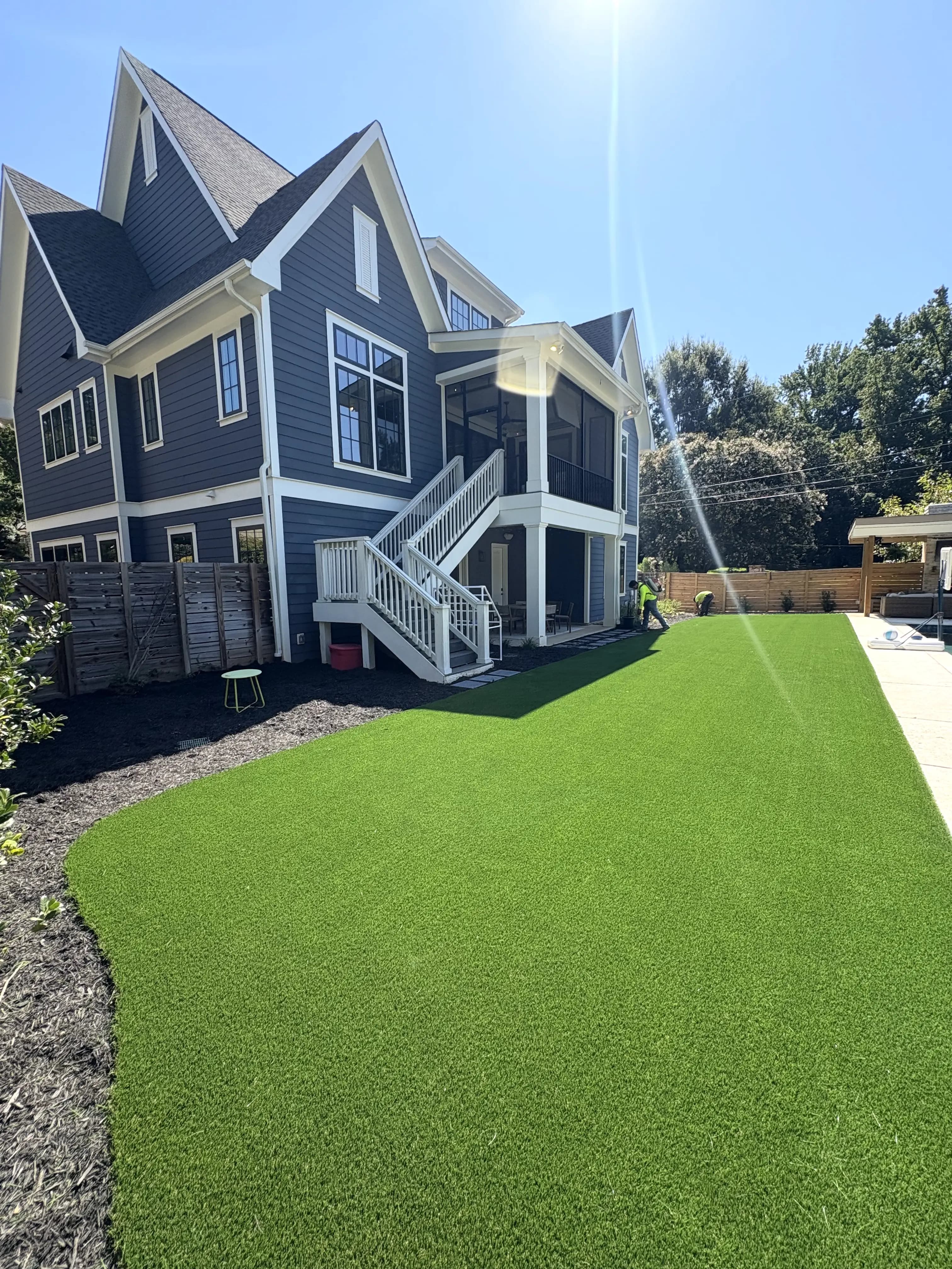 Expansive freshly installed artificial turf backyard at a modern blue craftsman home in Charlotte NC