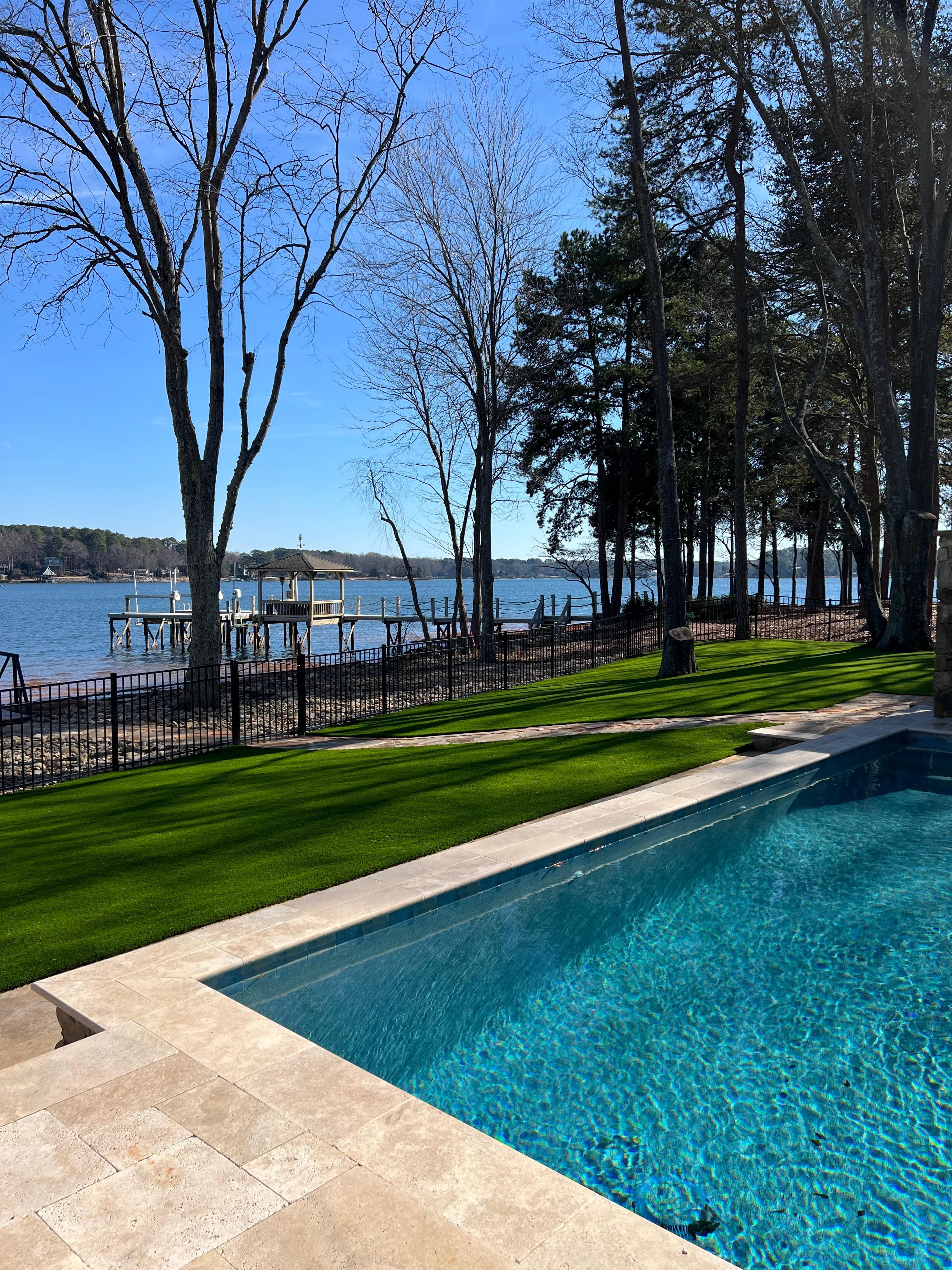 Pet-friendly synthetic grass surrounding beautiful poolside in Charlotte NC backyard
