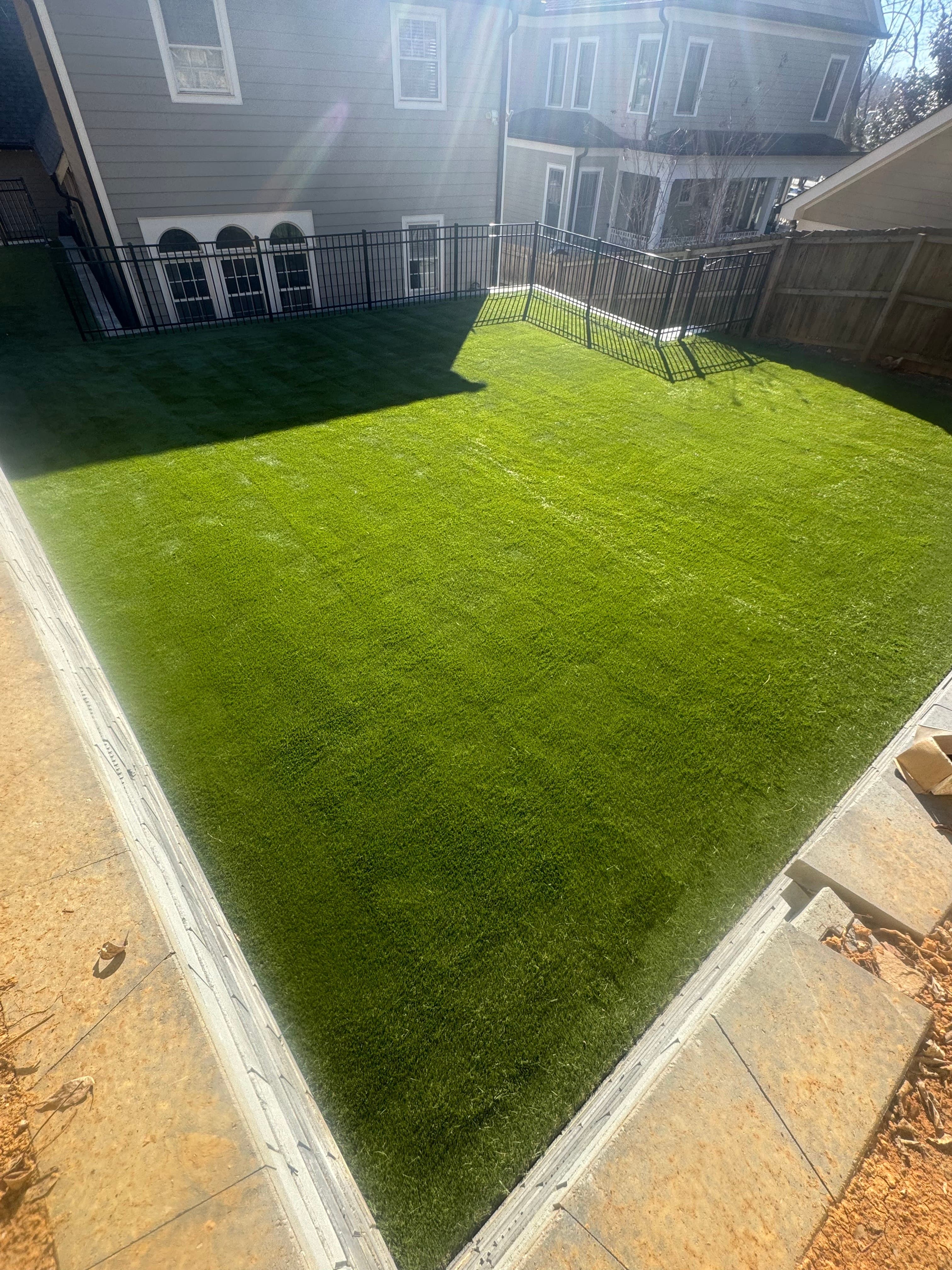 A clean and simple rectangular turf installation in an enclosed backyard.