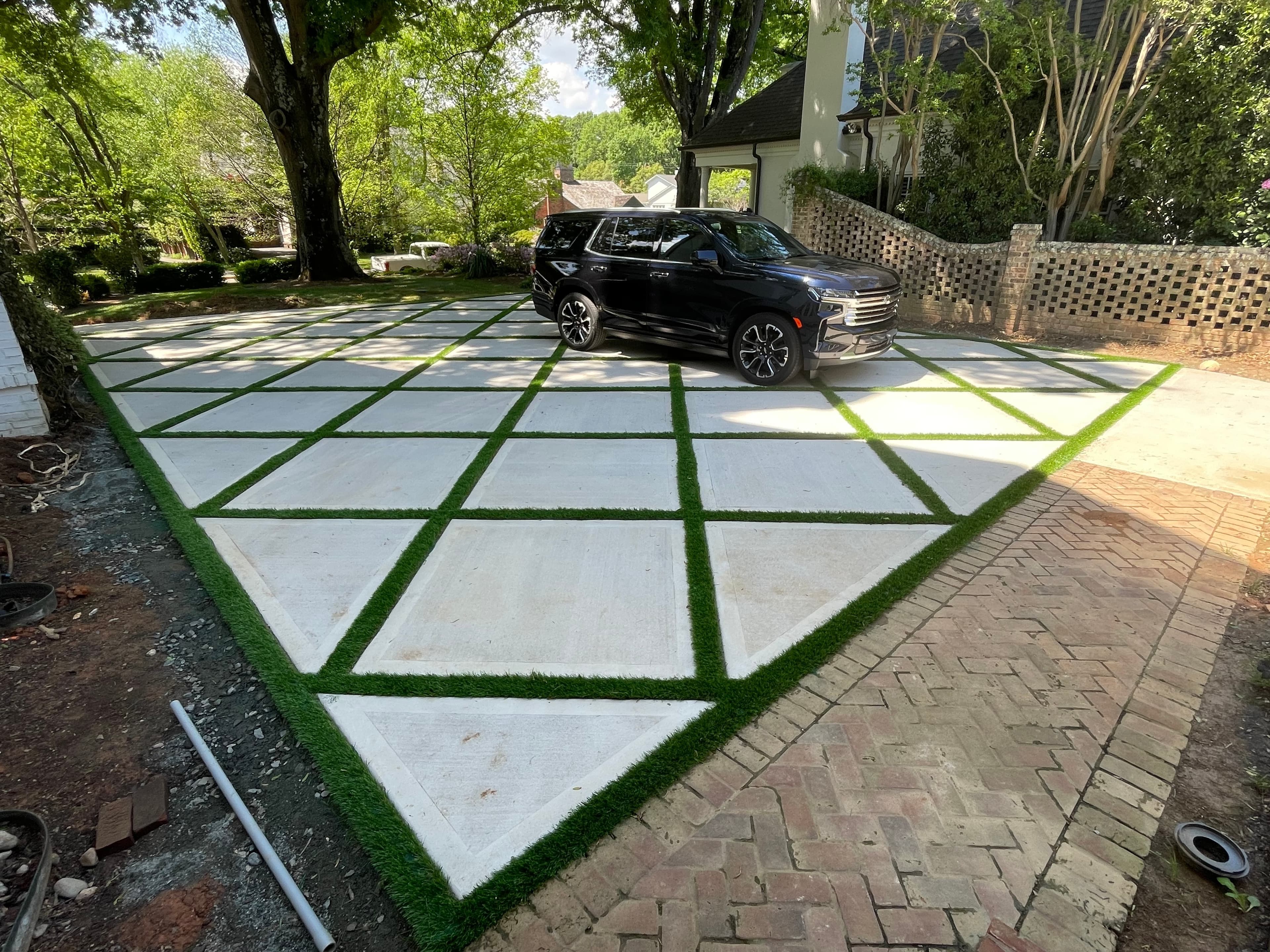 Modern commercial entrance combining synthetic turf with concrete pavers - Charlotte business property