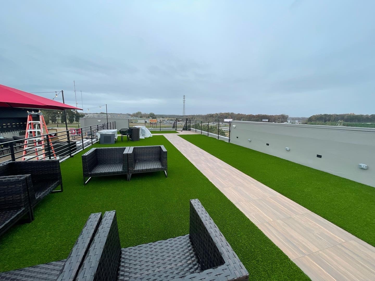 Commercial rooftop patio with low-maintenance artificial turf in Charlotte NC - Uptown city view
