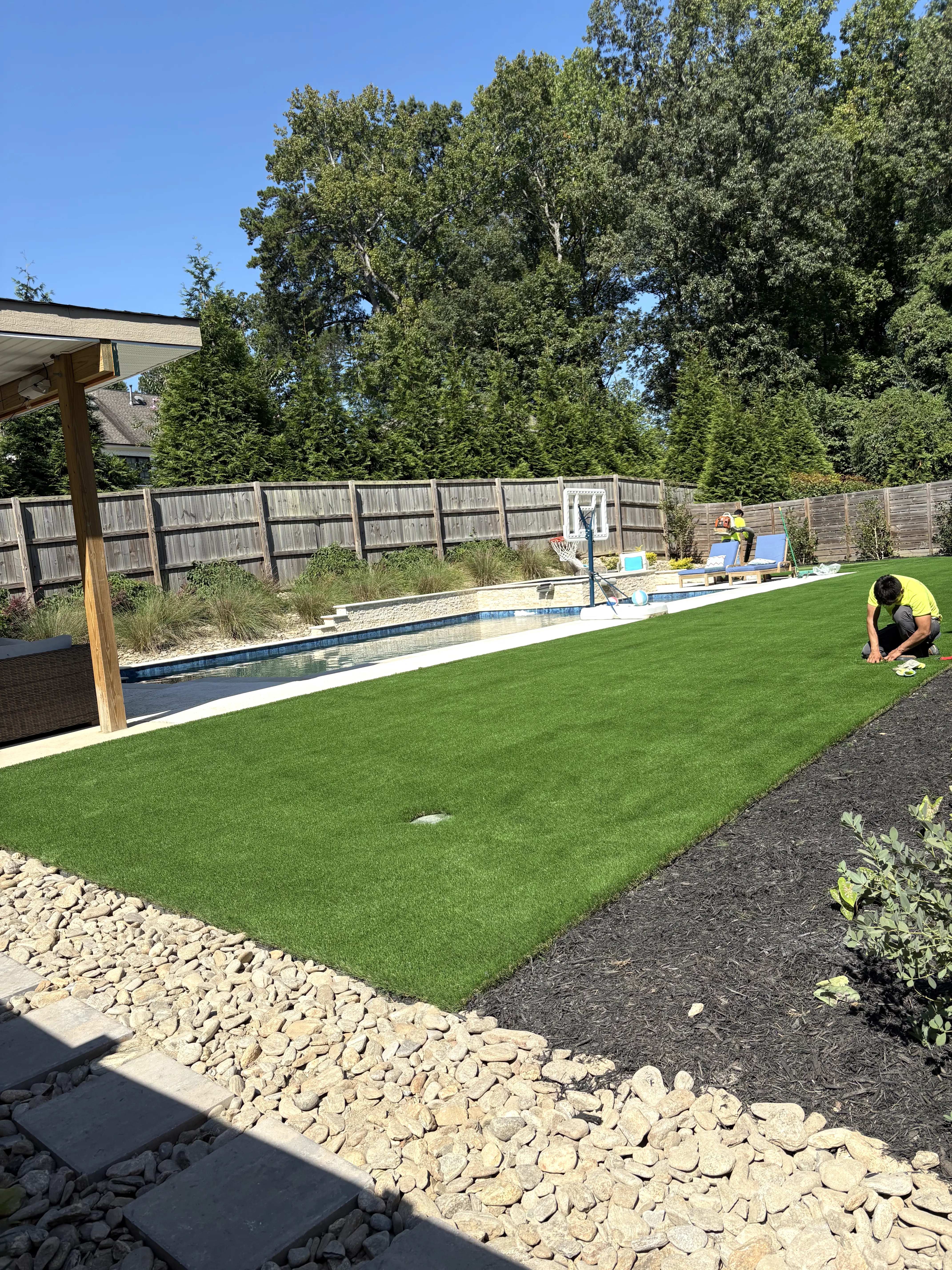 Pool Surround Turf — Pergola & River Rock View