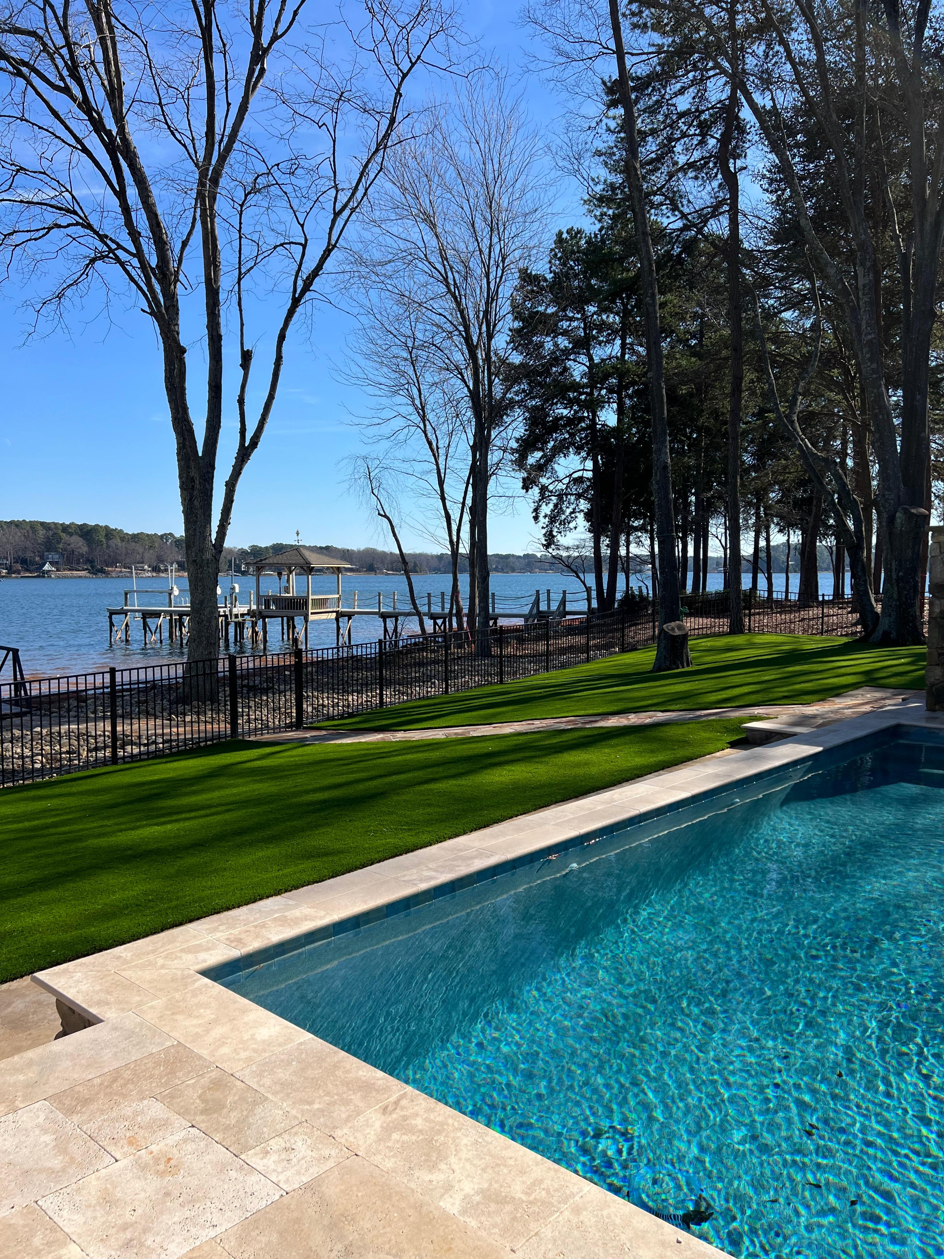 Pet-friendly synthetic grass surrounding beautiful poolside in Charlotte NC backyard